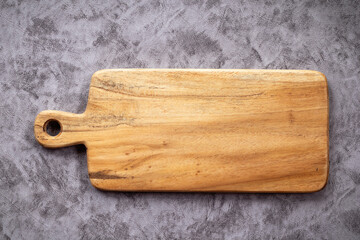 Top view of empty wooden cuttingboard on concrete background