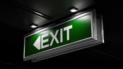 Obraz premium Bright Green Exit Sign Illuminating a Dark Ceiling in a Building