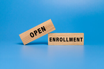 open enrollment words on wooden blocks isolated on blue background
