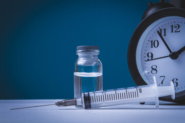 Time for vaccination. Watch and syringe with vaccine. Date and time of preventive vaccinations to population..