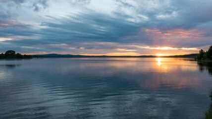 Naklejka premium Stunning sunset reflecting on tranquil lake water surface