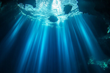 A deep, sapphire-blue cenote with crystal-clear water