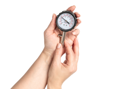 Female hands holding a tire pressure gauge showing 2 Bar, isolated on transparent background, automotive measurement tool for car tire maintenance and safety check.