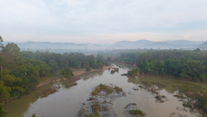 Aerial view tropical rainforest river curve sunrise with fog