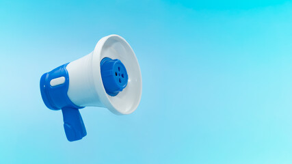 Blue and white megaphone on bright blue background with copy space. Communication, announcement, marketing, and attention concept.