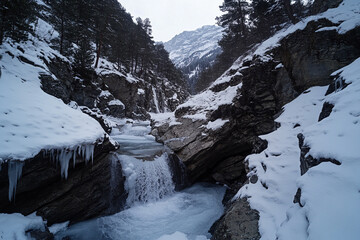 An untouched glacial valley, frozen waterfalls gleaming under the mystical glow of the galaxy