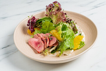 Sliced duck, greens, and orange come together for a delicious, appealing salad presentation