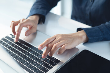 Close up, business woman hand typing, working on laptop computer with digital tablet on office...