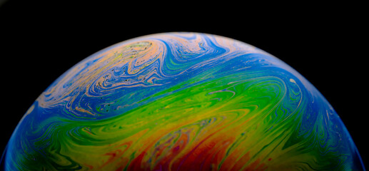 Closed up rainbow dynamic swirls wave and art patterns in bubbles isolated on black background. Abstract background. 