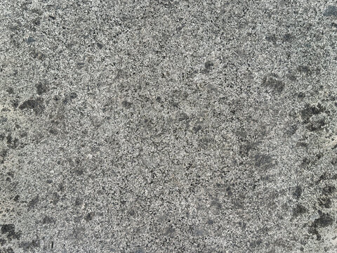 Close up of natural grey stone texture with black and white dots pattern, rough surfaces. Seamless background.