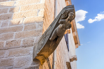 Stone corbel featuring female figure on brick building in Korcula © Iván Moreno