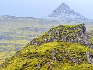 Fototapeta premium Klifbrekkufossar Waterfall in Mjóifjörður, Eastfjords of Iceland, Multi-Tiered Cascades through Mossy Cliffs
