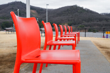 連なる赤い椅子と山の風景のある屋外空間