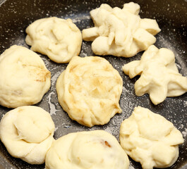 A pan of doughnuts with a variety of shapes and sizes