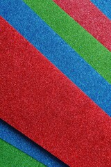 Diagonal stripes of textured paper in red, blue, and green