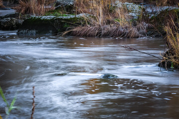 Artificial fish ladder in a river with water flowing over concrete steps, designed to help wild salmon migrate upstream through the dam, symbol of ecological restoration