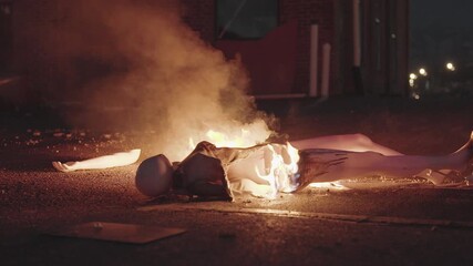 Eerie flames engulf burning mannequin on dark street at night - Powered by Adobe