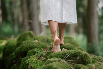 Natural close-up of female feet walking barefoot on mossy ground in a quiet forest atmosphere © Thilo Wagner