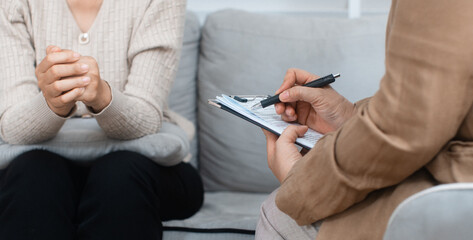 Close-up of psychologist hand writing, taking note about patient, listening to patient at...