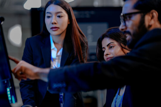 A lead data analyst points out a critical insight on a dashboard to his two female colleagues, reviewing complex datasets and visualizations for a business intelligence report. - Powered by Adobe