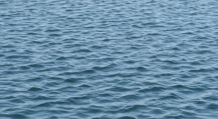 Obraz premium An expanse of rippling blue water fills the frame Waves of varying sizes create texture