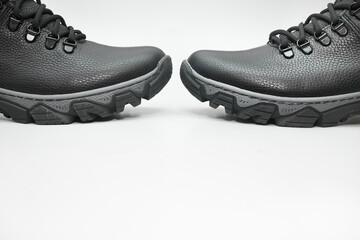 Pair of black winter leather warm boots with laces on white