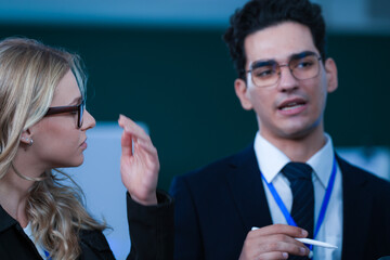 Dynamic duo collaborates late night. Focused male and female professionals discuss project details...