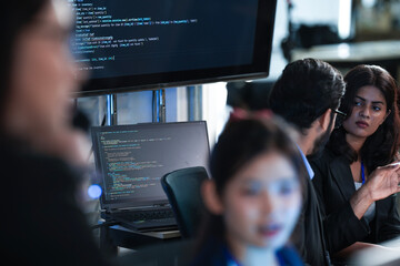Monitoring AI training progress. Specialists oversee a machine learning model's training observing real time metrics on screen discussing adjustments via tablet interface late night.