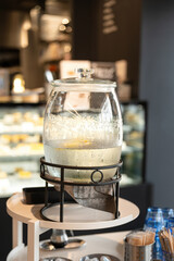 An iced water glass bottle for self service at the breakfast buffet line.  Food and drink object photo, selective focus.
