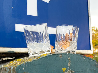Two empty crystal glasses on a blue sign with autumn leaves
