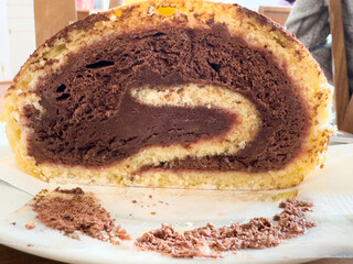 Chocolate and vanilla swirl cake roll on white plate