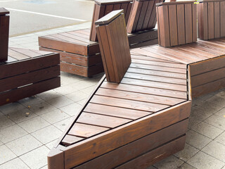 Geometric wooden outdoor benches on urban pavement