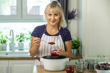 Raspberry jam in the hands of a woman. Selective focus.