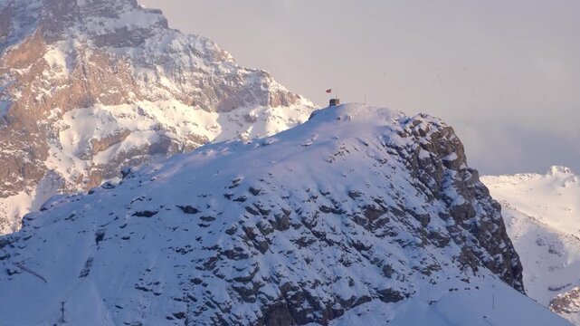 Cinematic view of snowy Mount Sumbul in Hakkari at sunset, majestic snow-capped mountain peaks under blue sky with clouds, winter landscape in Eastern Turkey, 4K 25fps. 4