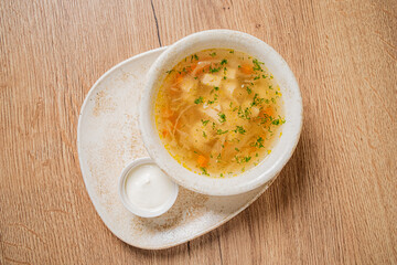Savory broth filled with noodles and fresh herbs, beautifully served with a creamy dip