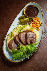 A delightful dish of tender meat, creamy mashed potatoes, and vibrant sides makes a perfect meal