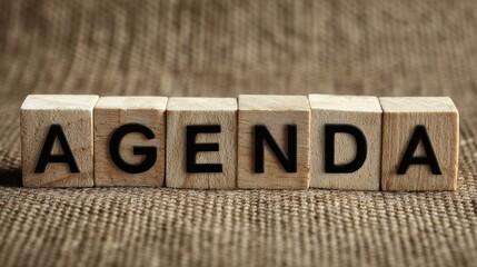 A High Resolution image of wooden blocks spelling out the word agenda on a textured background.