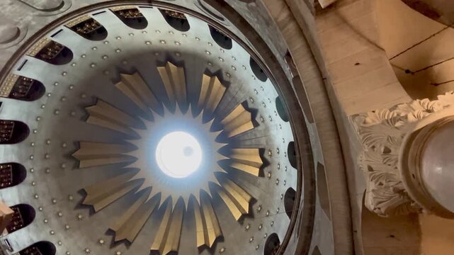 Jerusalem, Israel, 23 October 2025, Inside the Temple of the Lord at the Church of the Holy Sepulchre, the golden dome and frescoes shine under radiant light as the camera circles.