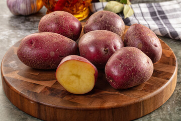 Raw red organic potato over board