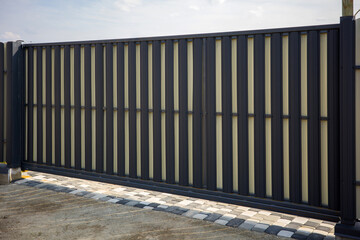 Modern metal fence for fencing the yard and garage area under construction.