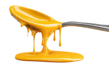 Dripping bright yellow sauce on a silver spoon, isolated image