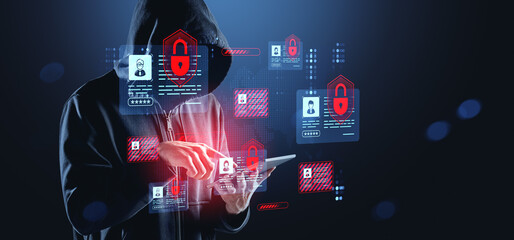 Cybercriminal in hoodie using tablet with glowing digital securi