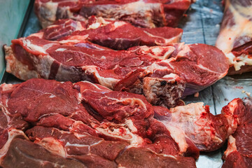 Large pieces of raw meat lying on the counter.
