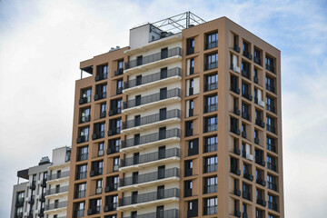 Fototapeta premium An office or residential building with many apartments is a multi-storey building set against a blue sky with few clouds.