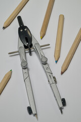 compass and scissors on white sheet of paper