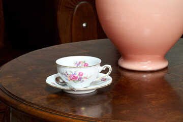 teacup and vase  on round wooden table