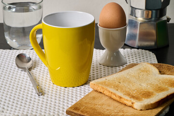 cup of coffee, egg and toast on black furniture