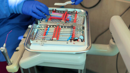 Professional dentist tools arranged on sterilized metal tray in modern dental clinic. Clean medical instruments ready for treatment procedure.