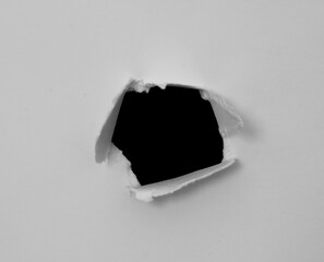 torn ripped hole paper on black background.
