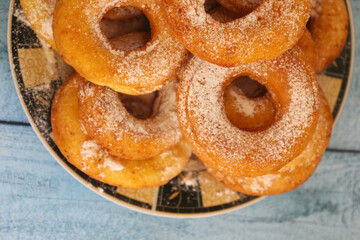 Cozy homemade donuts on rustic wooden kitchen table. Sweet dessert and comfort food concept showing cozy lifestyle, family cooking and slow living mood.